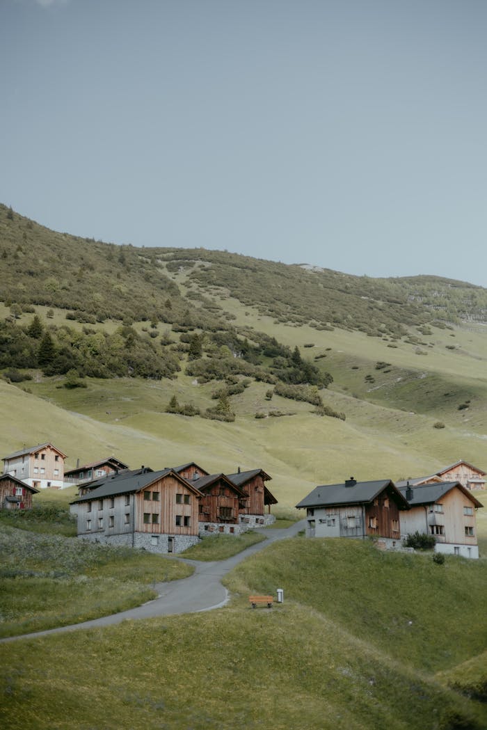 Charming wooden houses in the picturesque village of Malbun, Liechtenstein, set in lush green hills.